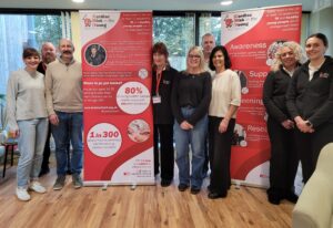 A group of people standing near a charity banner