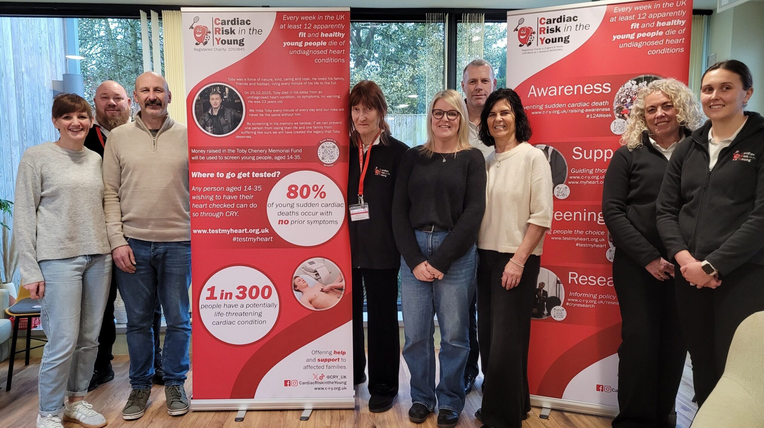 A group of people standing near a charity banner