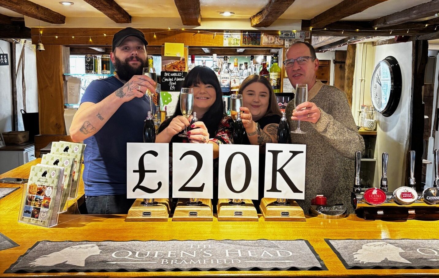 Staff at a pub celebrate after raising £20,000 for charity
